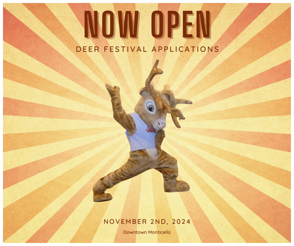 A deer mascot is standing in front of a poster that says now open deer festival applications