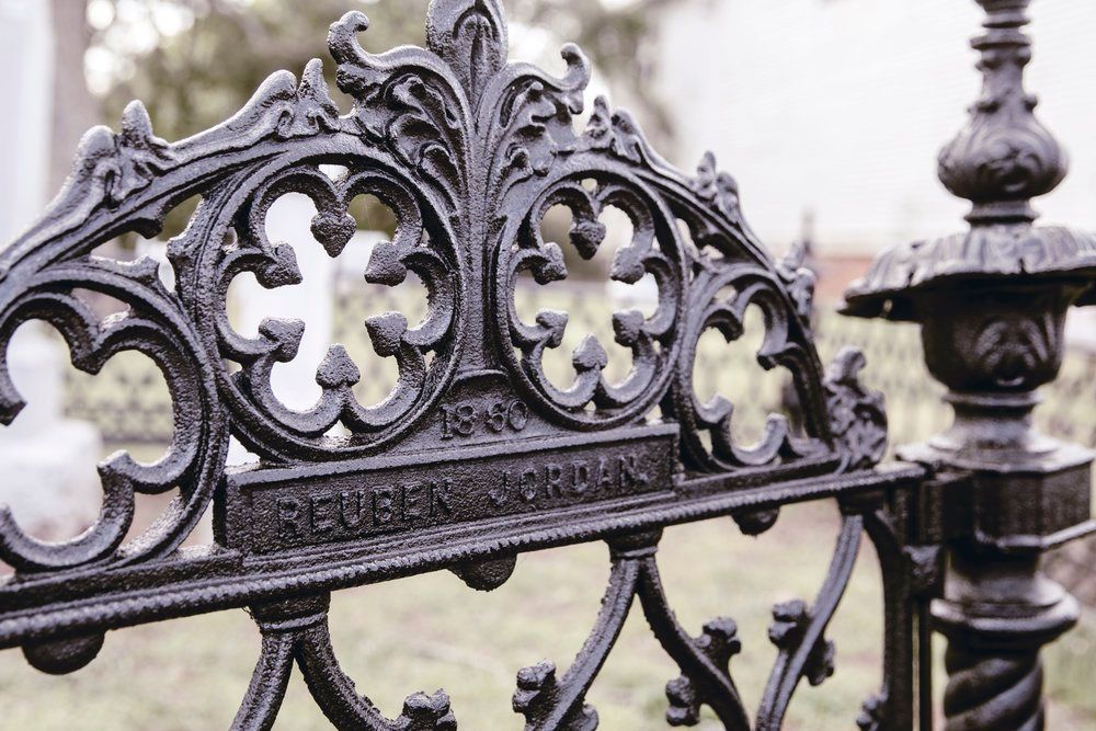 A close up of a wrought iron fence in a cemetery