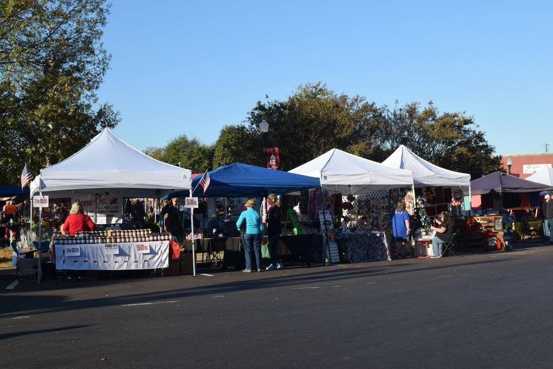 A row of tents are lined up on the side of the road.