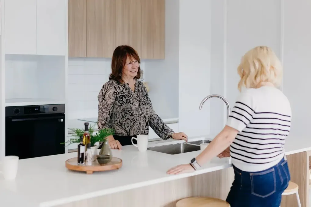 Residents talking in modern village kitchen