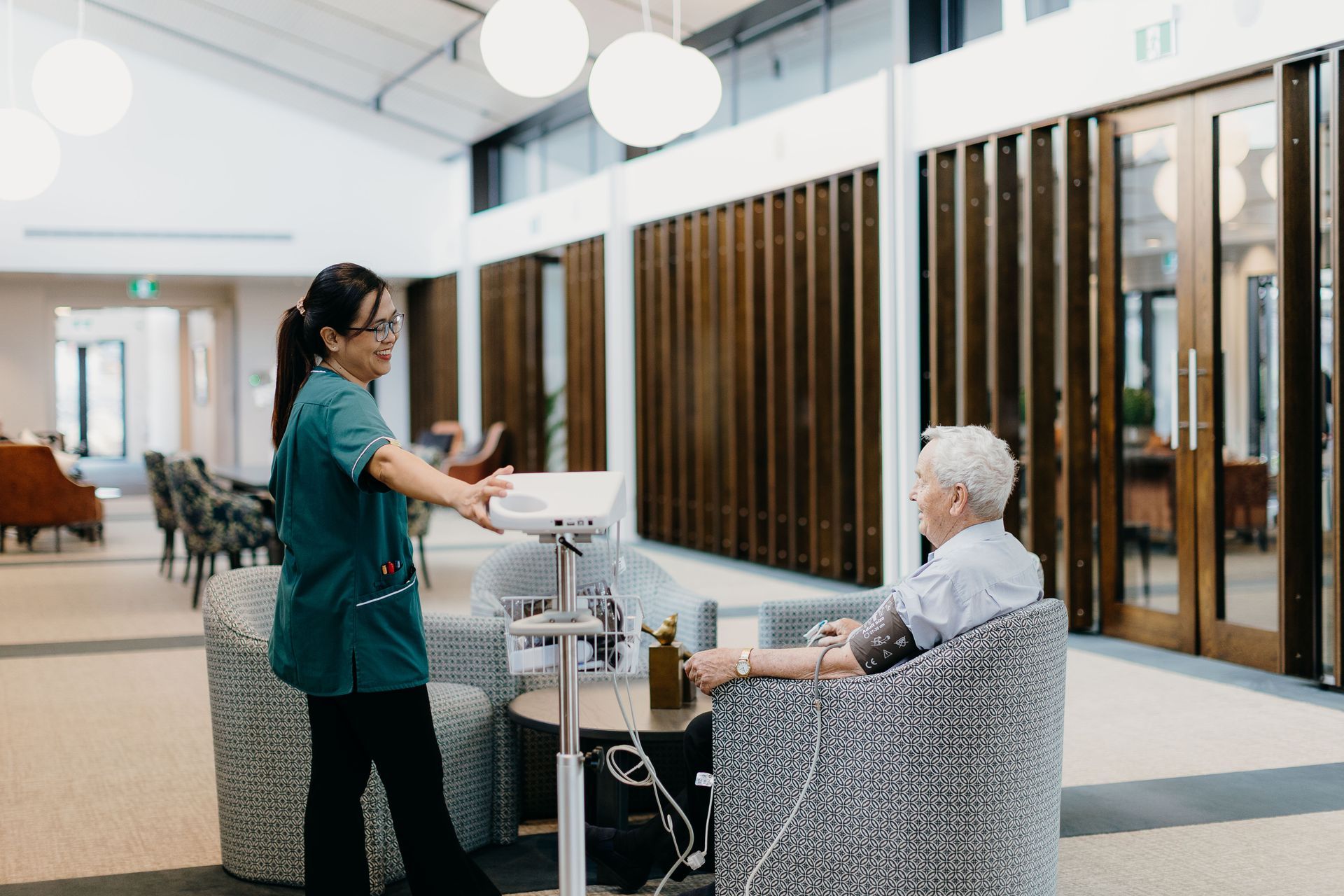 Nurse taking patient's blood pressure in a modern waiting room.