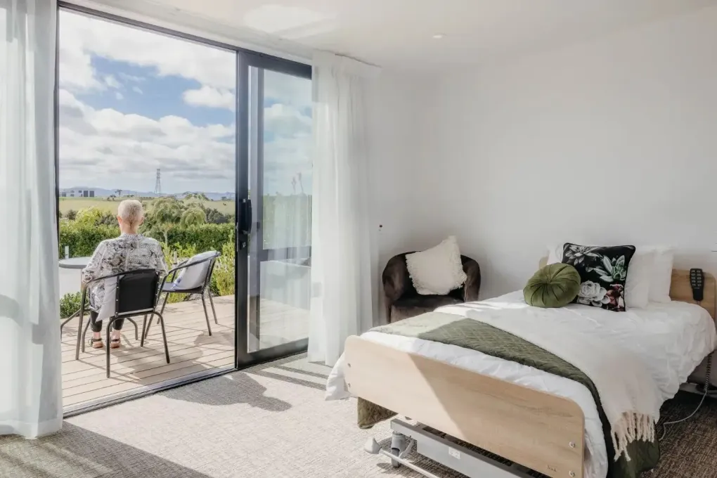 Resident relaxing on balcony outside care room