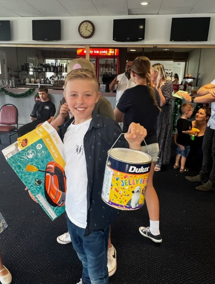 A Young Boy Is Holding A Bucket Of Dulux Paint — Unique Life Services In Nelson Bay, NSW