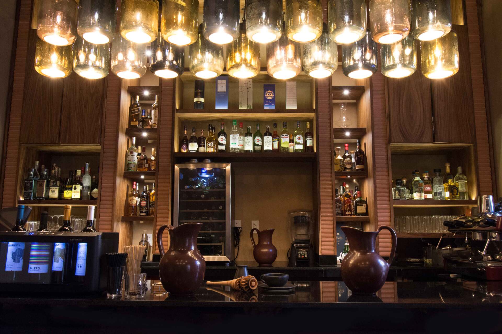 Un bar con muchas botellas en los estantes.