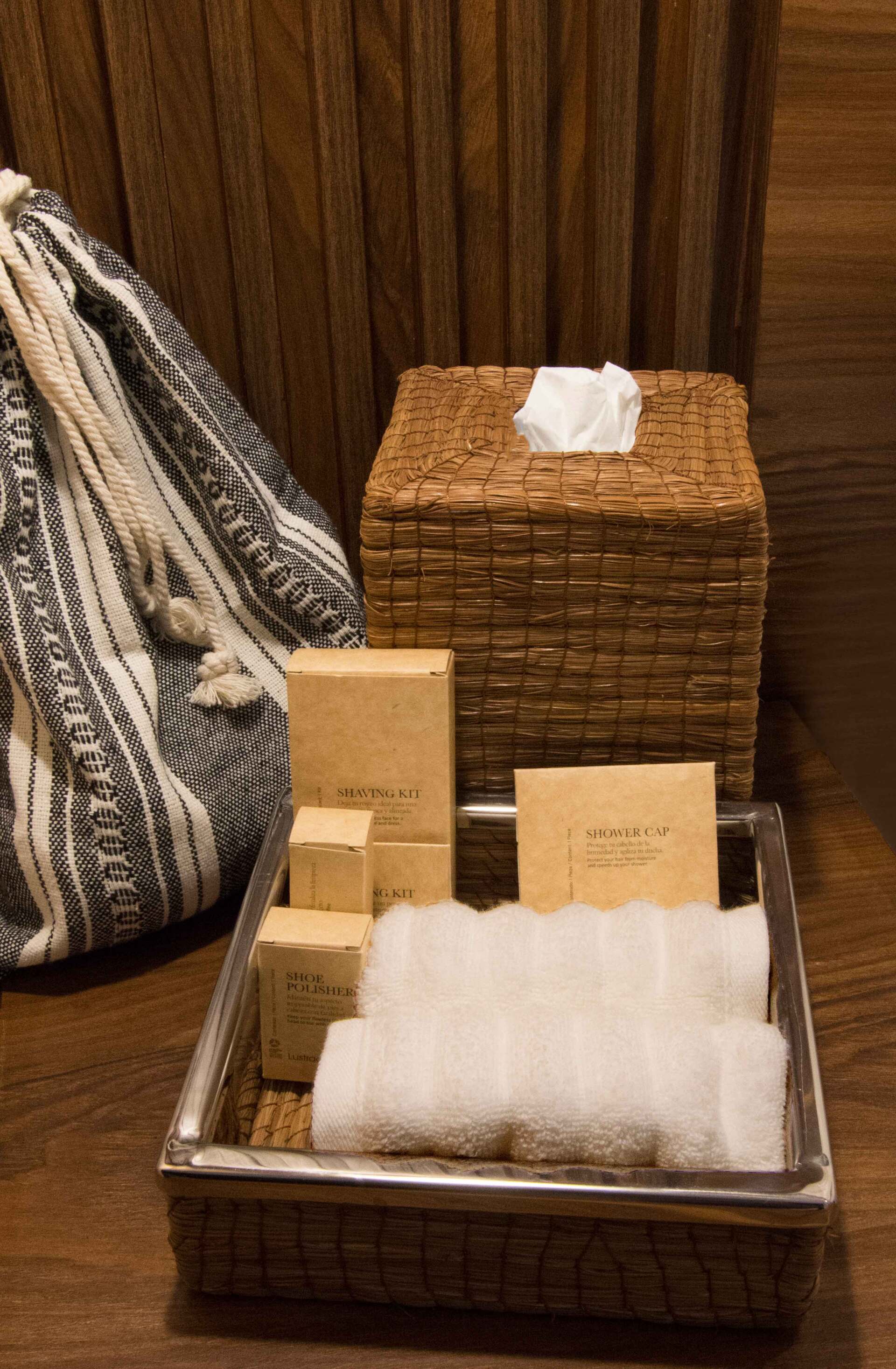Una cesta llena de toallas, jabones y una caja de pañuelos.