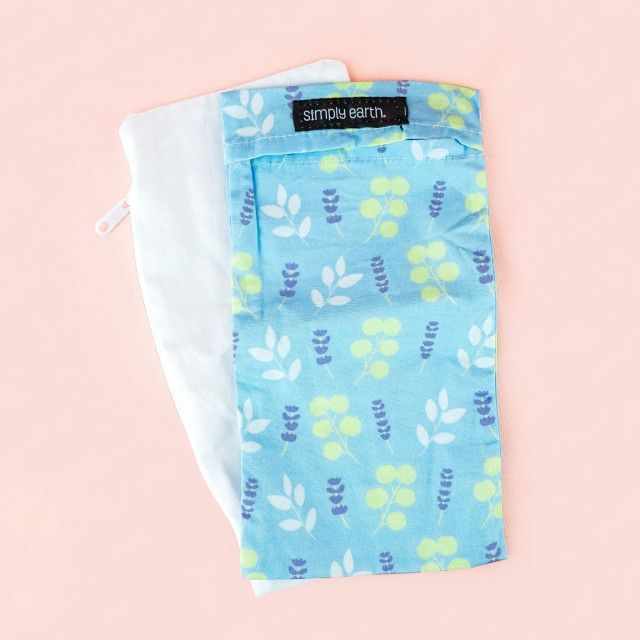 A blue pillow with a pattern on it is sitting on a pink surface.