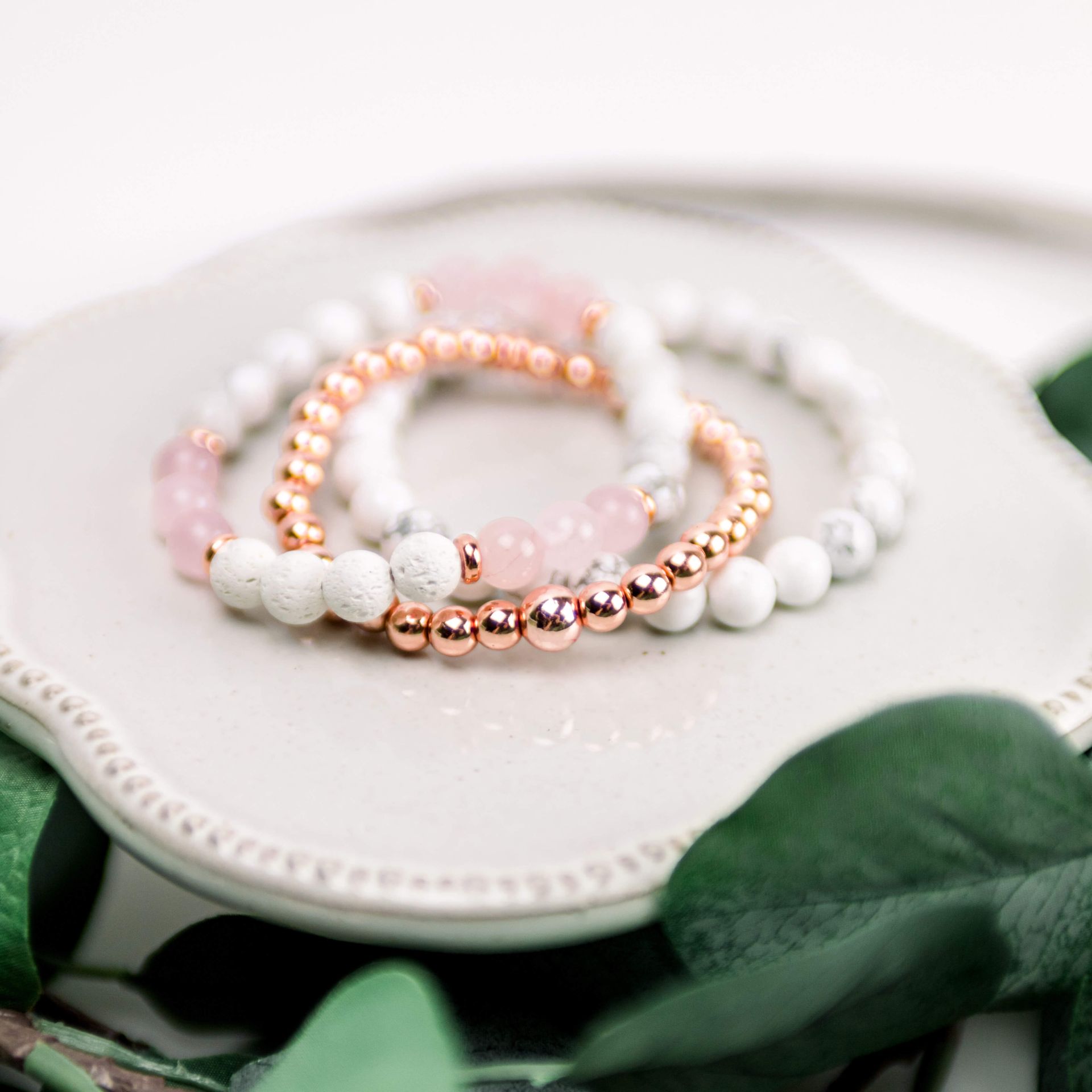 A close up of a bracelet with black and white beads on a plate.