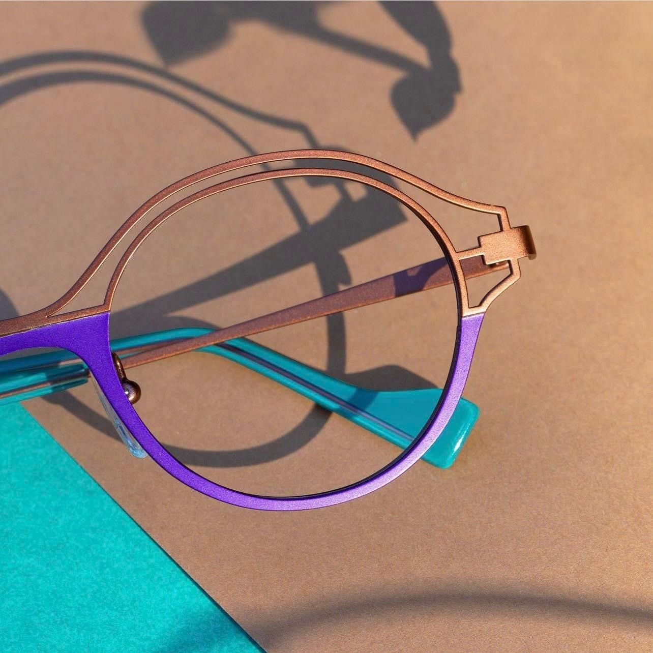 Un paio di occhiali viola e marroni posati su un tavolo