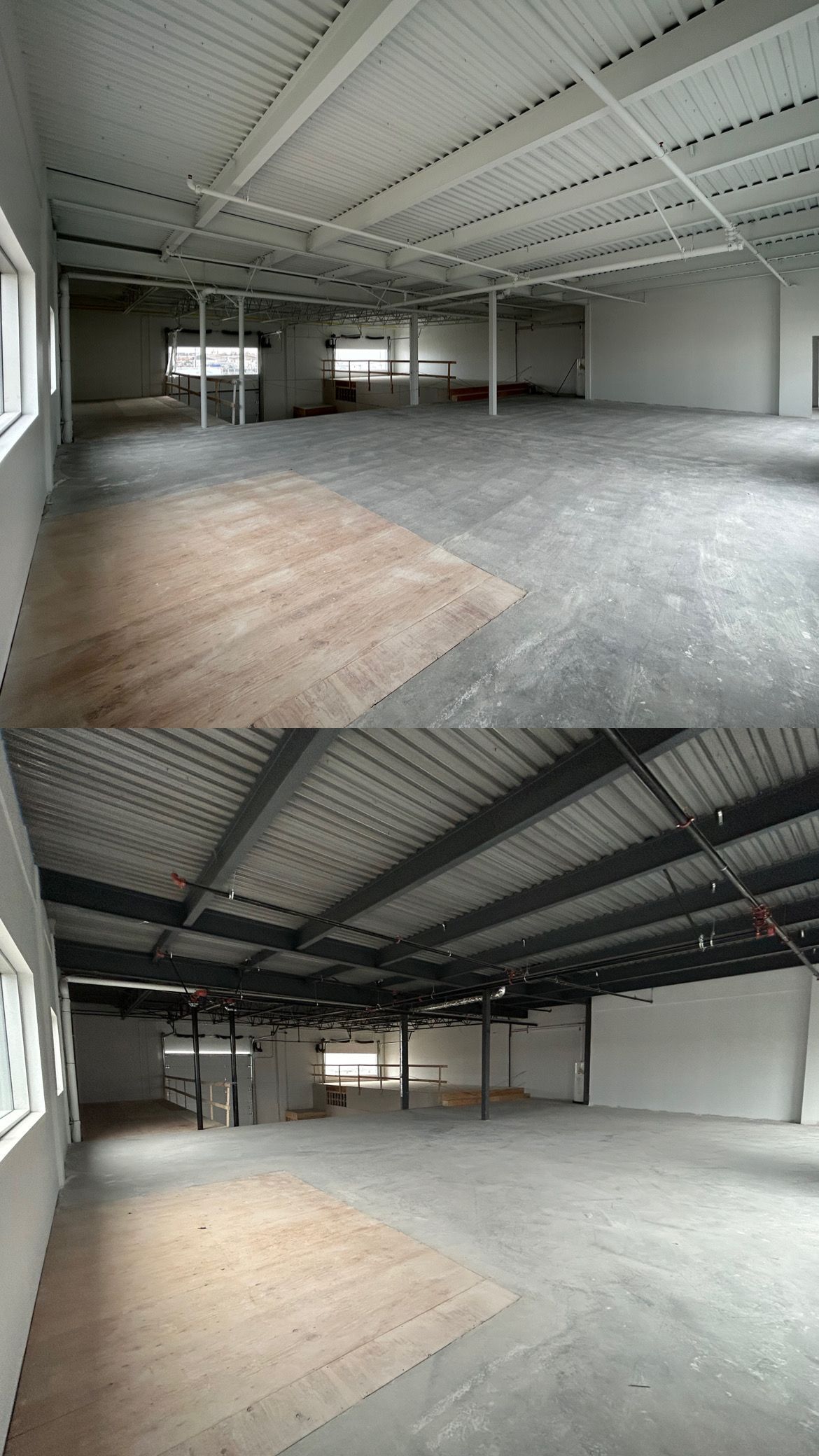 Un grand entrepôt vide avec un plancher en bois et un toit en métal.