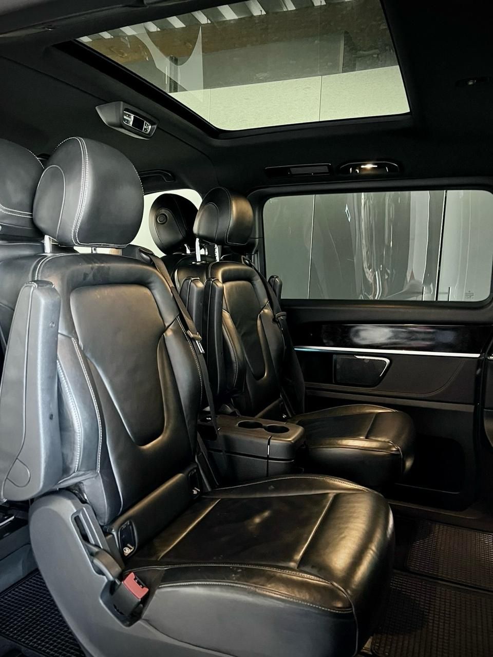 The inside of a car with a sunroof and leather seats.