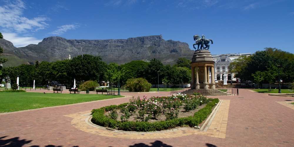 A statue in a park with a mountain in the background