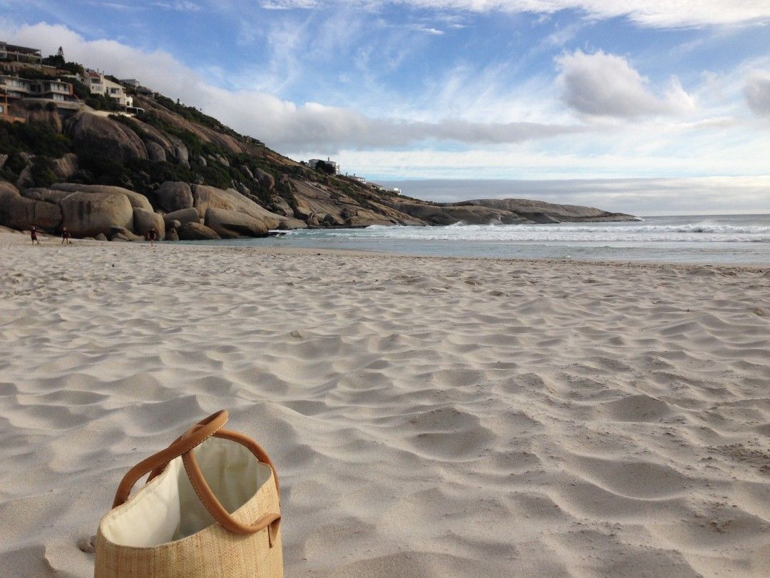 A basket is sitting on a sandy beach near the ocean.