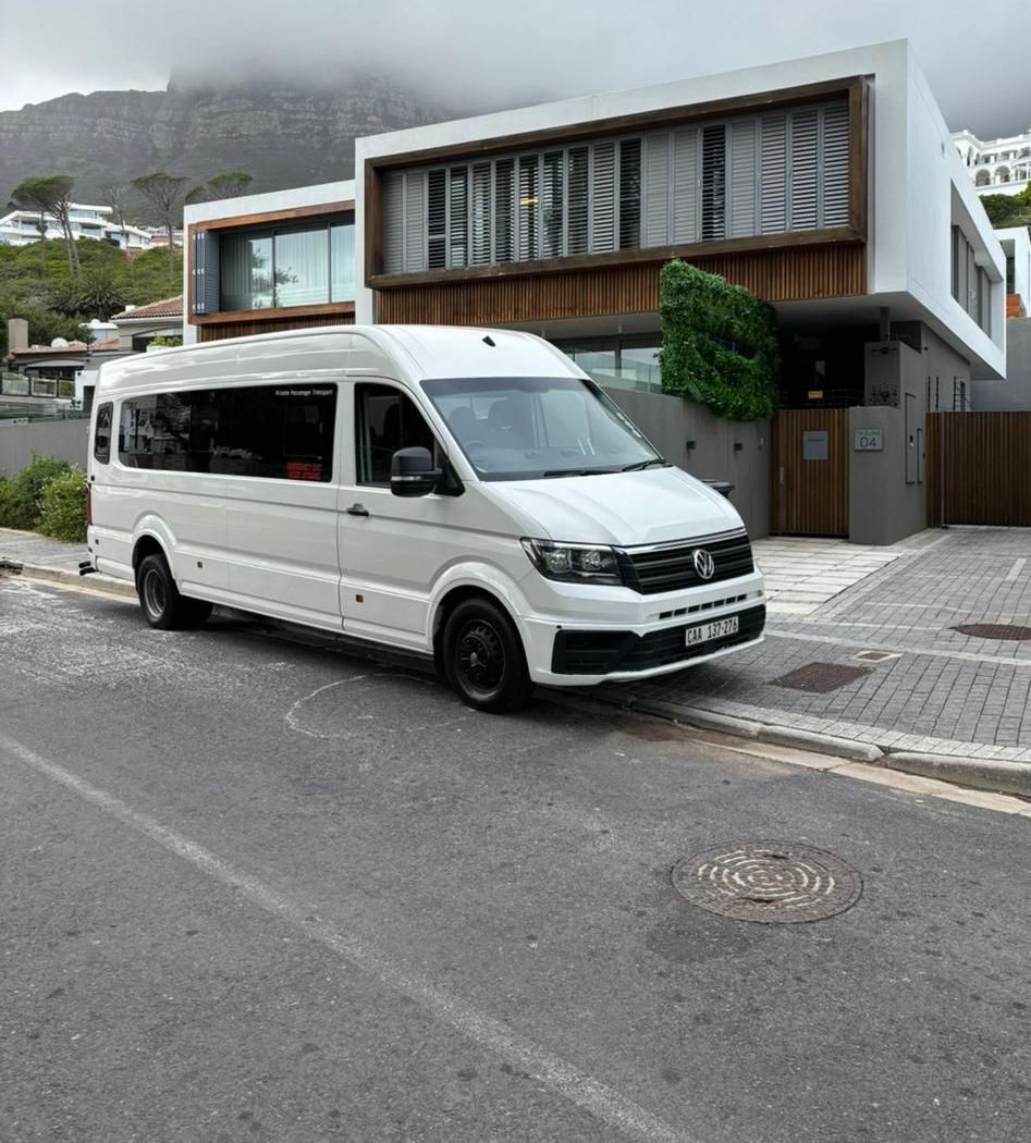 A white van is parked on the side of the road in front of a house.