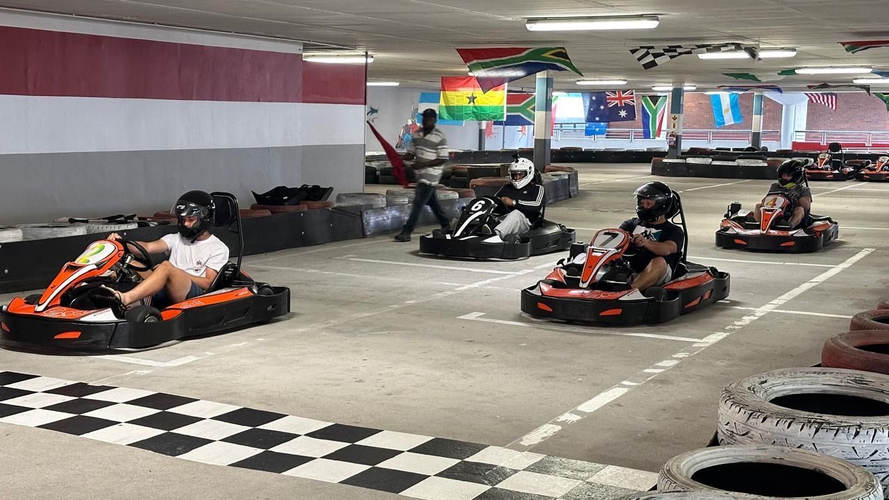 A group of people are riding go karts on a track.
