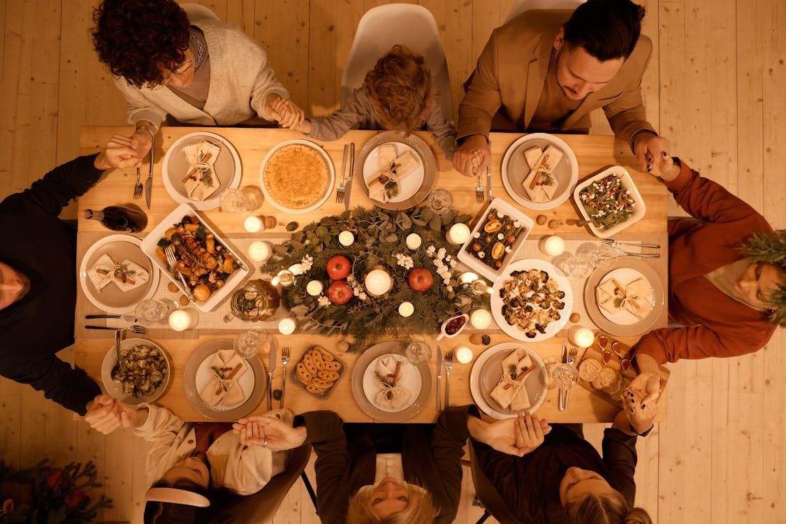 A group of people are sitting around a table with plates of food.