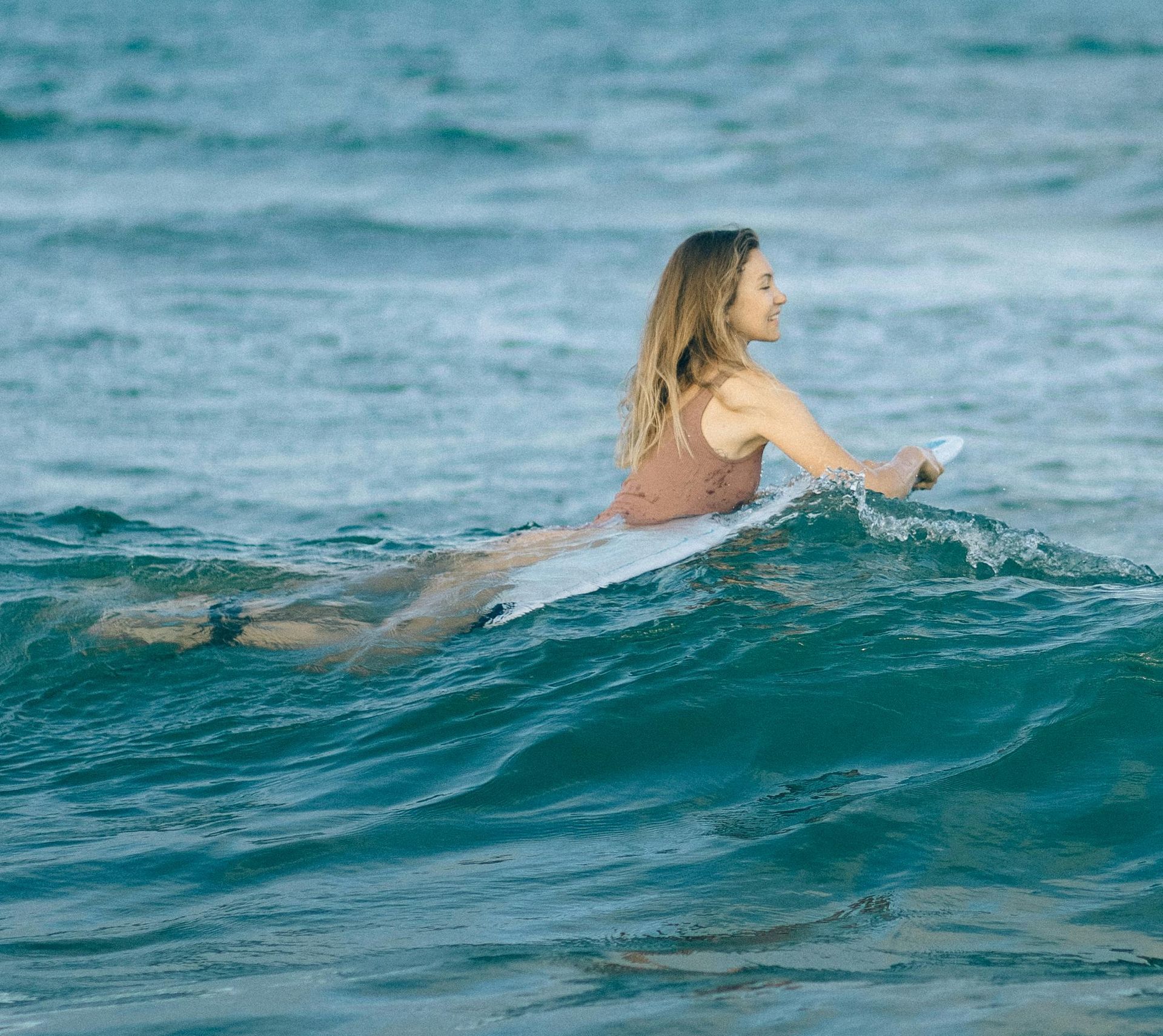 A woman is riding a wave on a surfboard in the ocean.