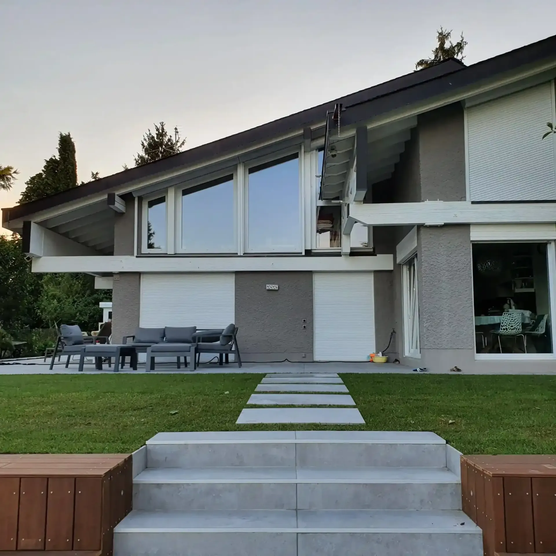 Une maison avec beaucoup de fenêtres et d'escaliers qui y mènent