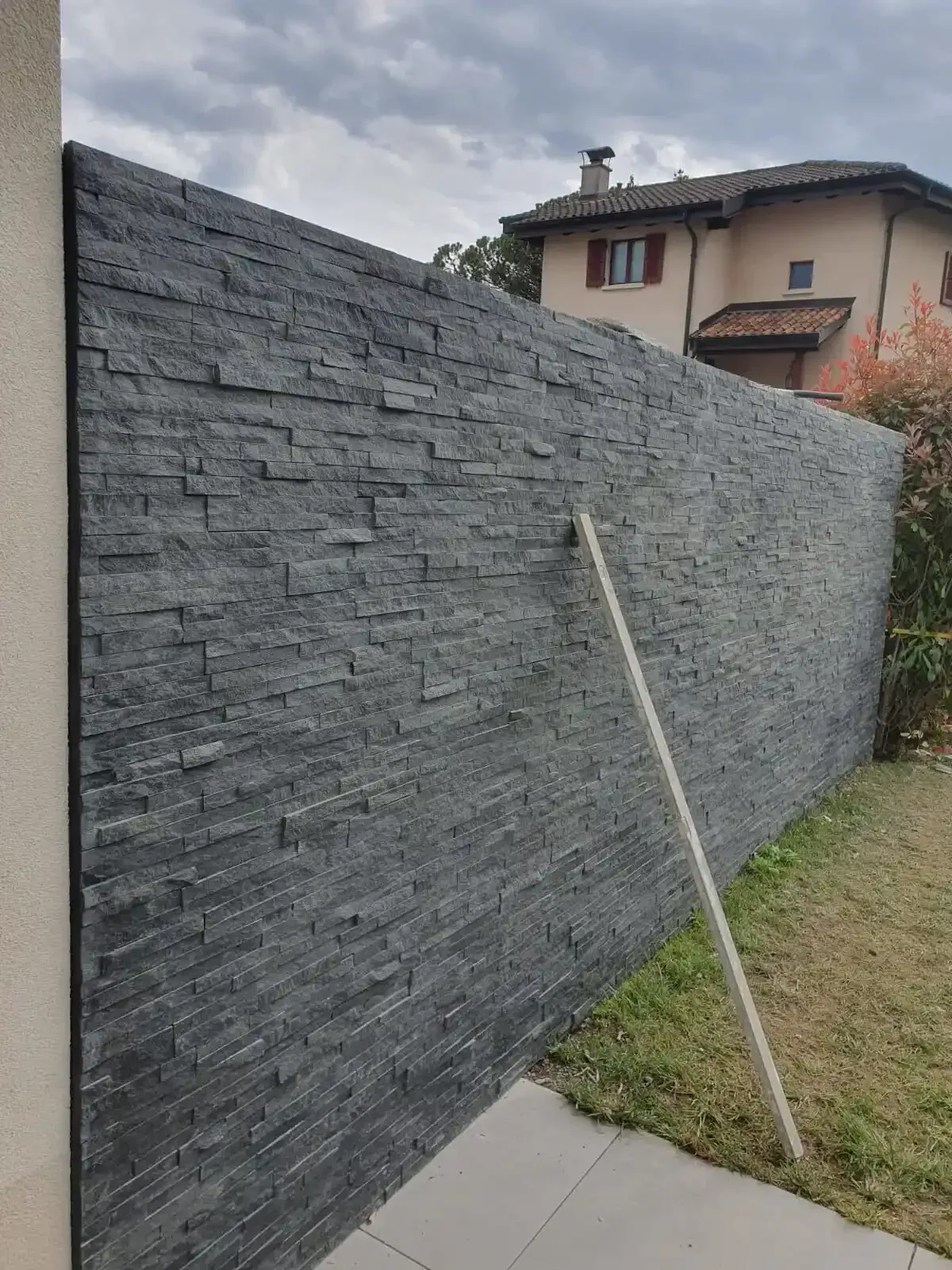 Un mur de briques avec une maison en arrière-plan