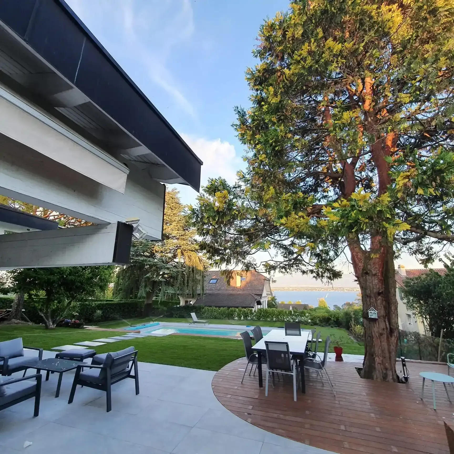 Un patio avec une table et des chaises devant une maison