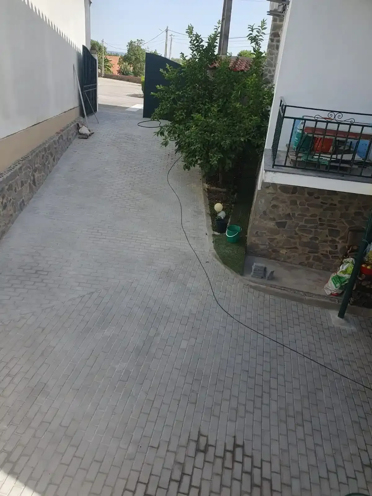 Une allée en briques menant à une maison avec un balcon