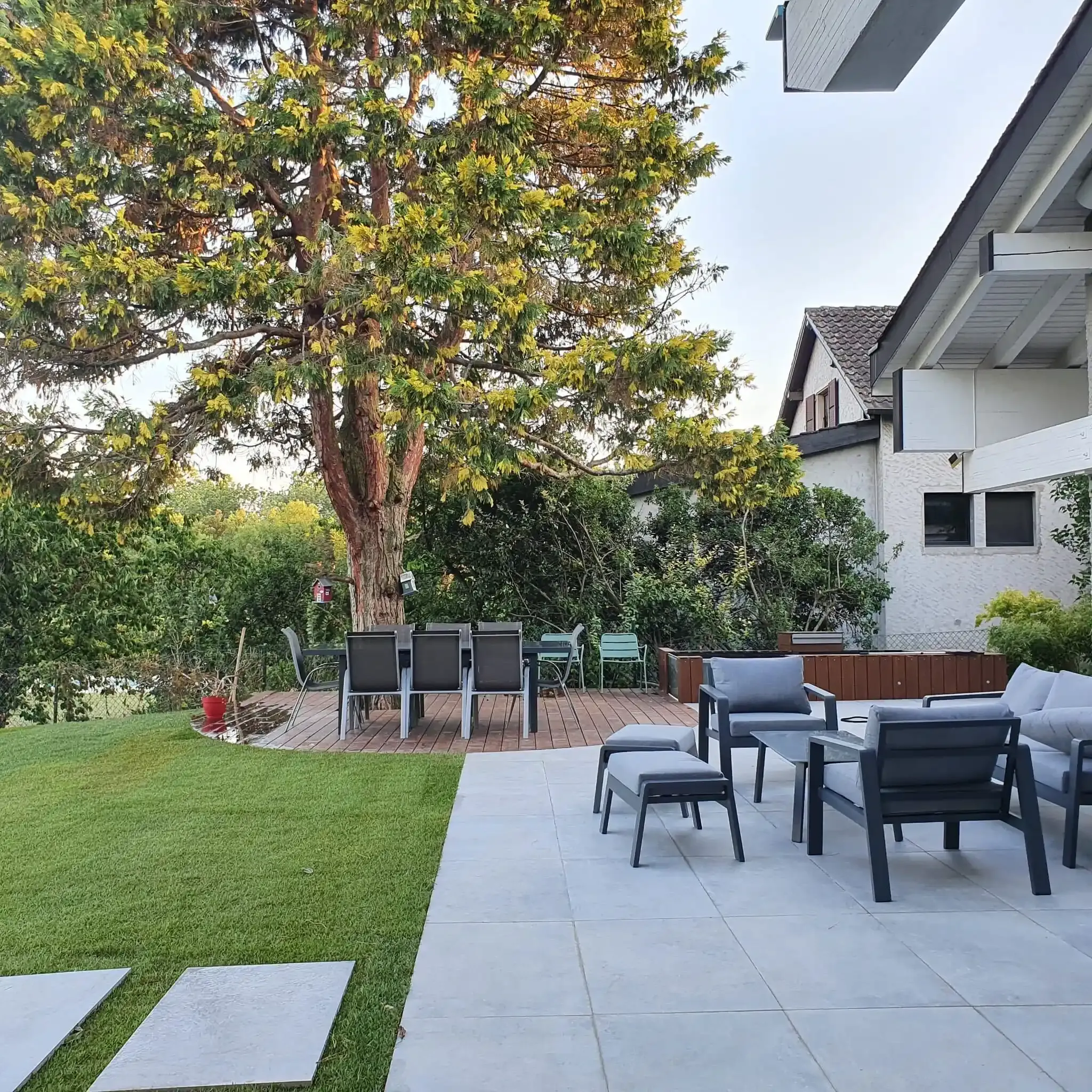 Un patio avec des chaises et des tables devant une maison