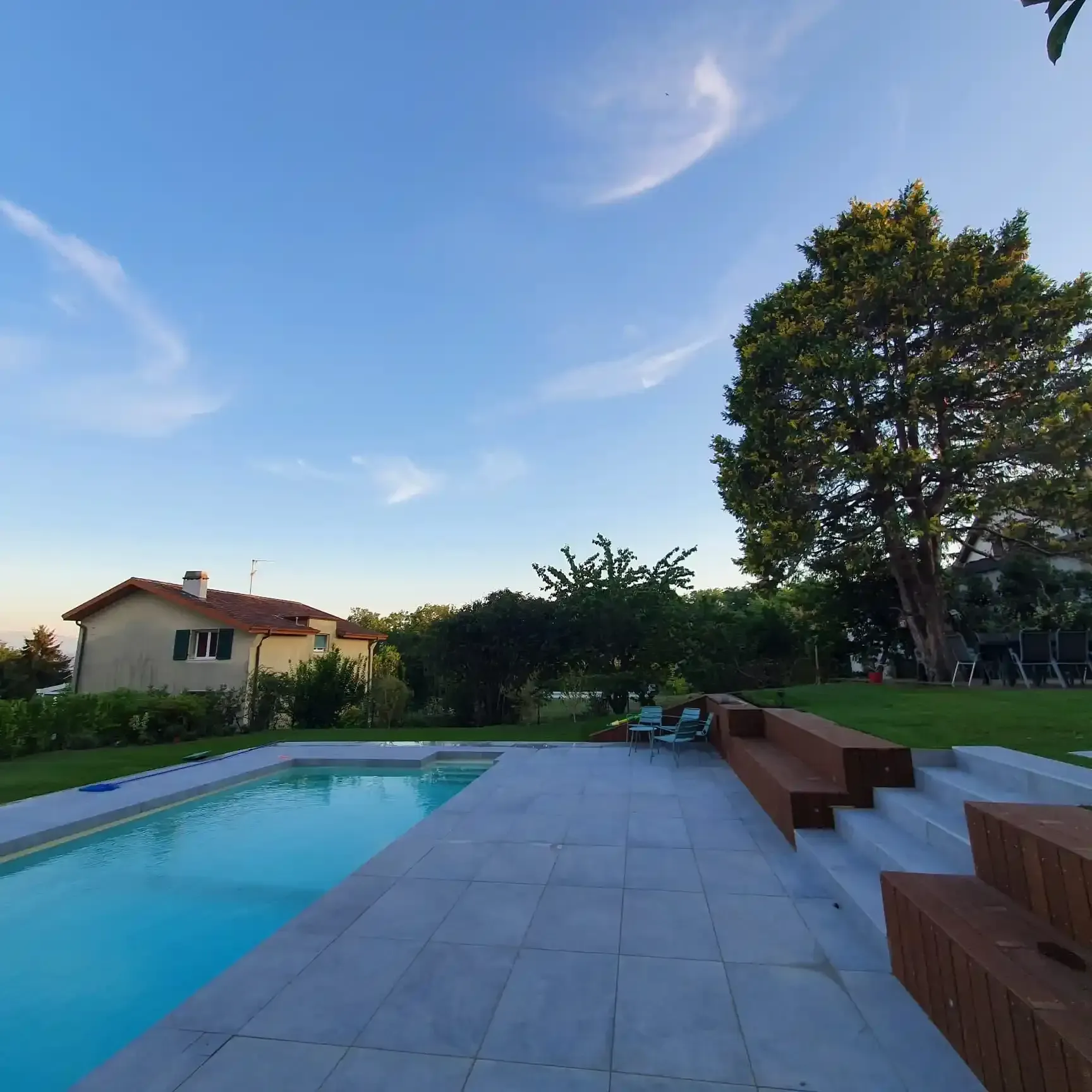 Une grande piscine avec une maison en arrière-plan