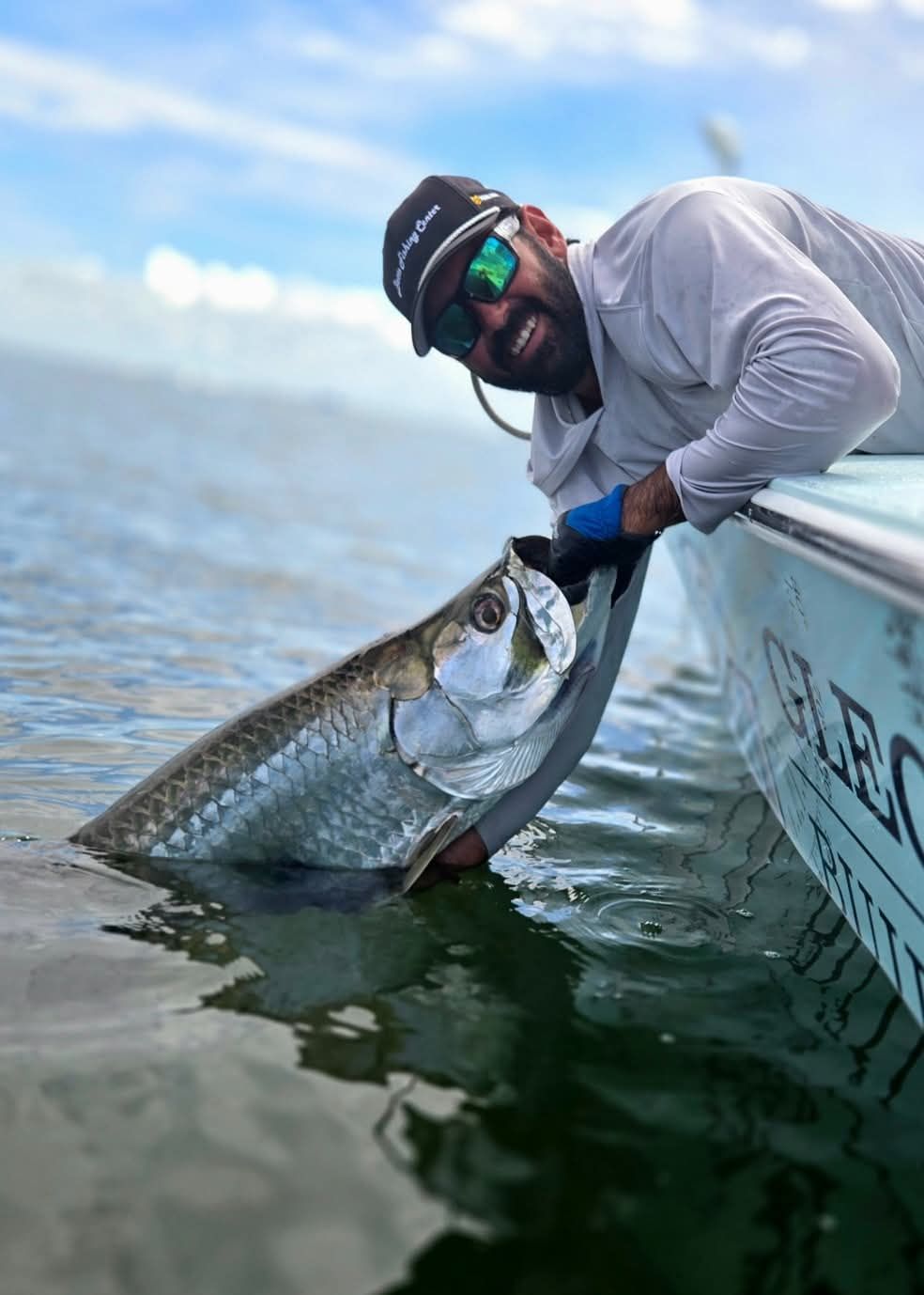 Two men are holding fish in their hands on a boat
