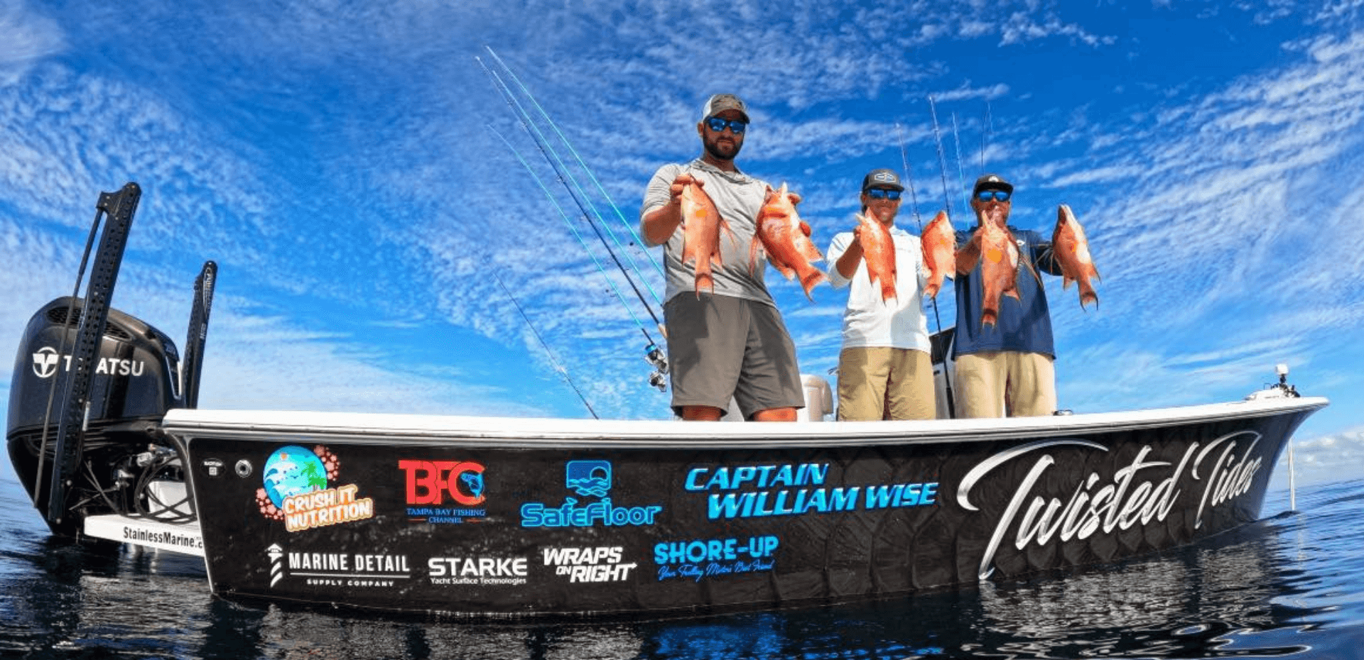 A group of men are standing on a boat holding fish.