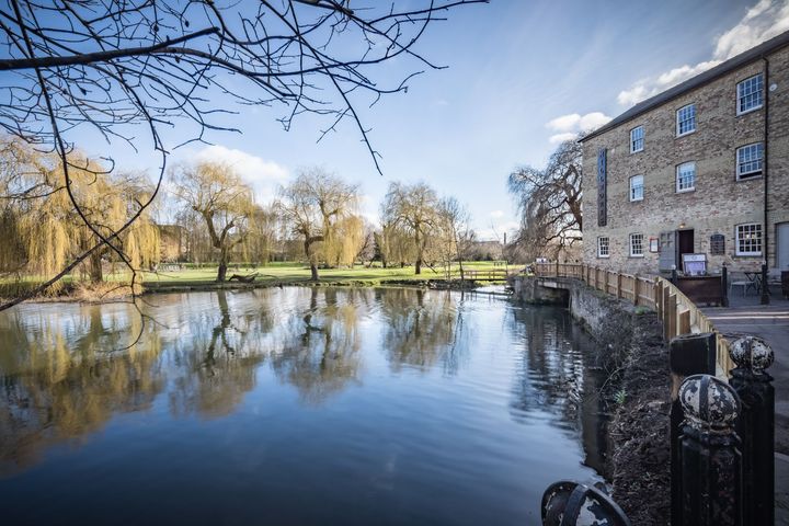 A large body of water surrounded by trees and a building.
