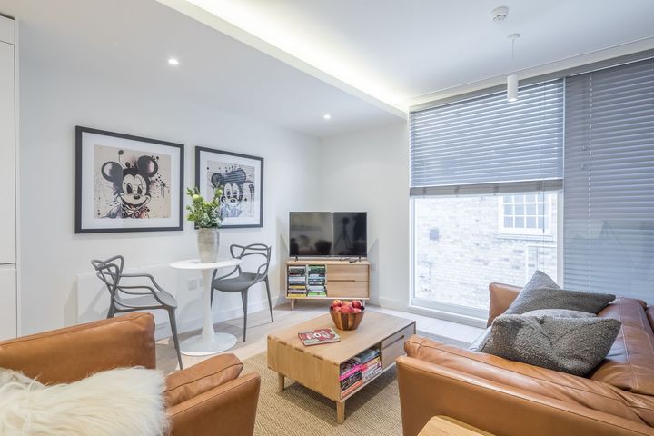 A living room with a couch , chairs , table and television.
