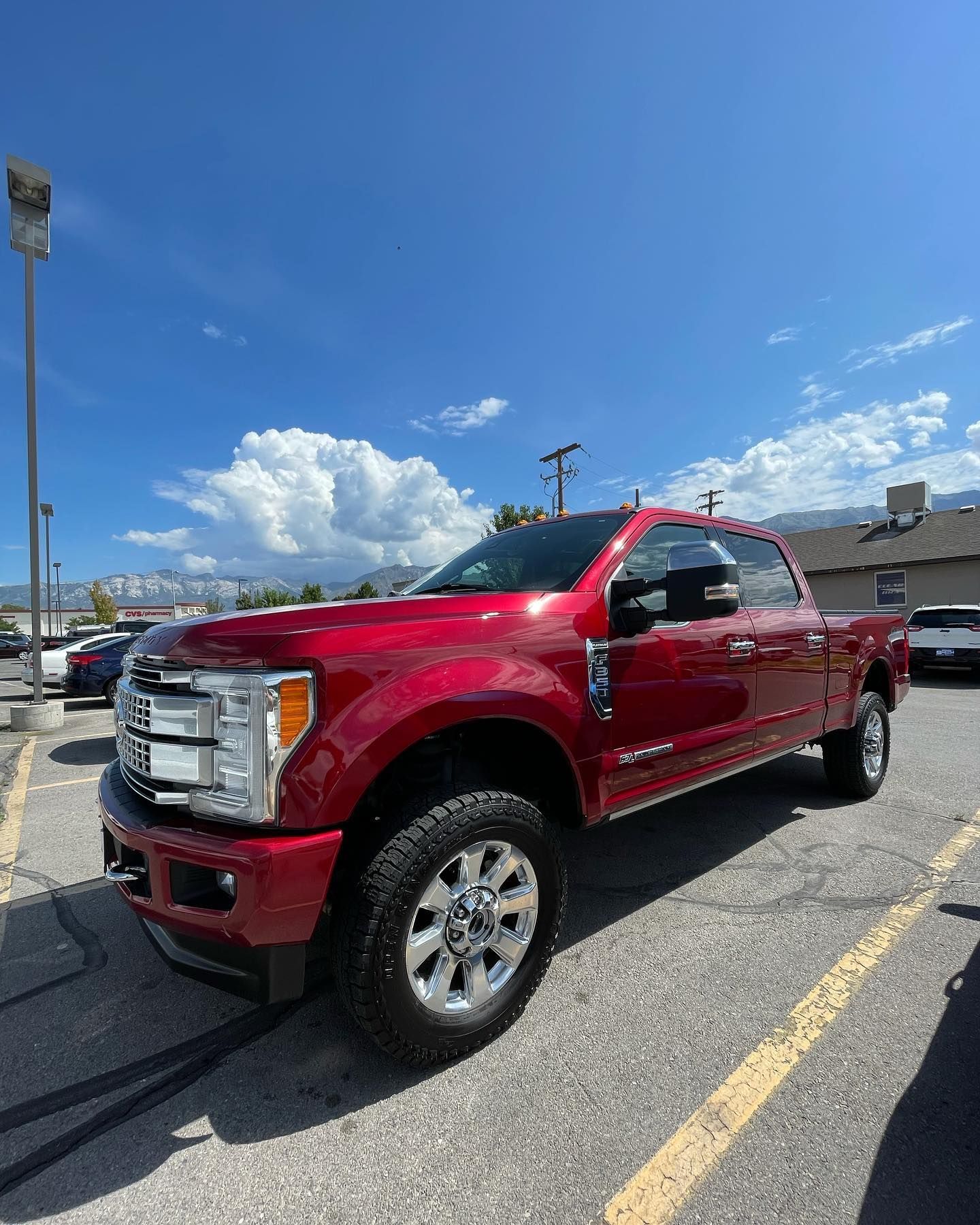 A red ford truck is parked in a parking lot.