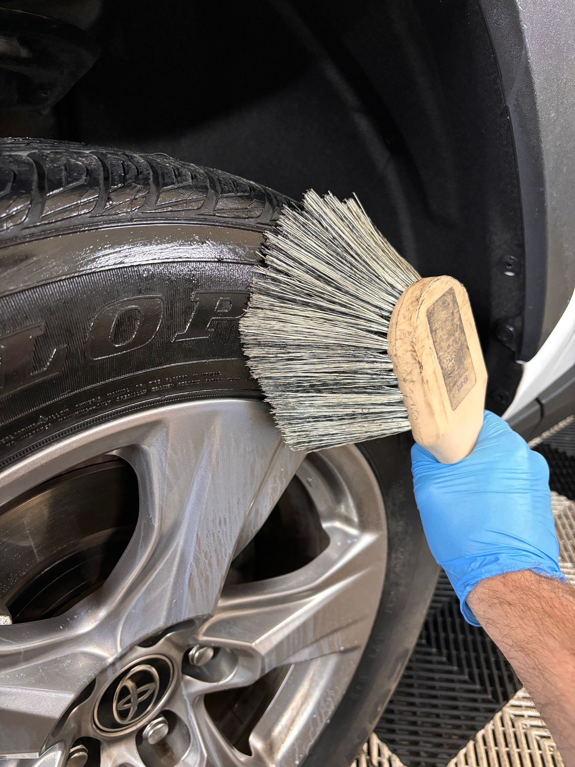 Tire shine is applied to the tire of a Toyota RAV4 at Stokes Auto Spa.