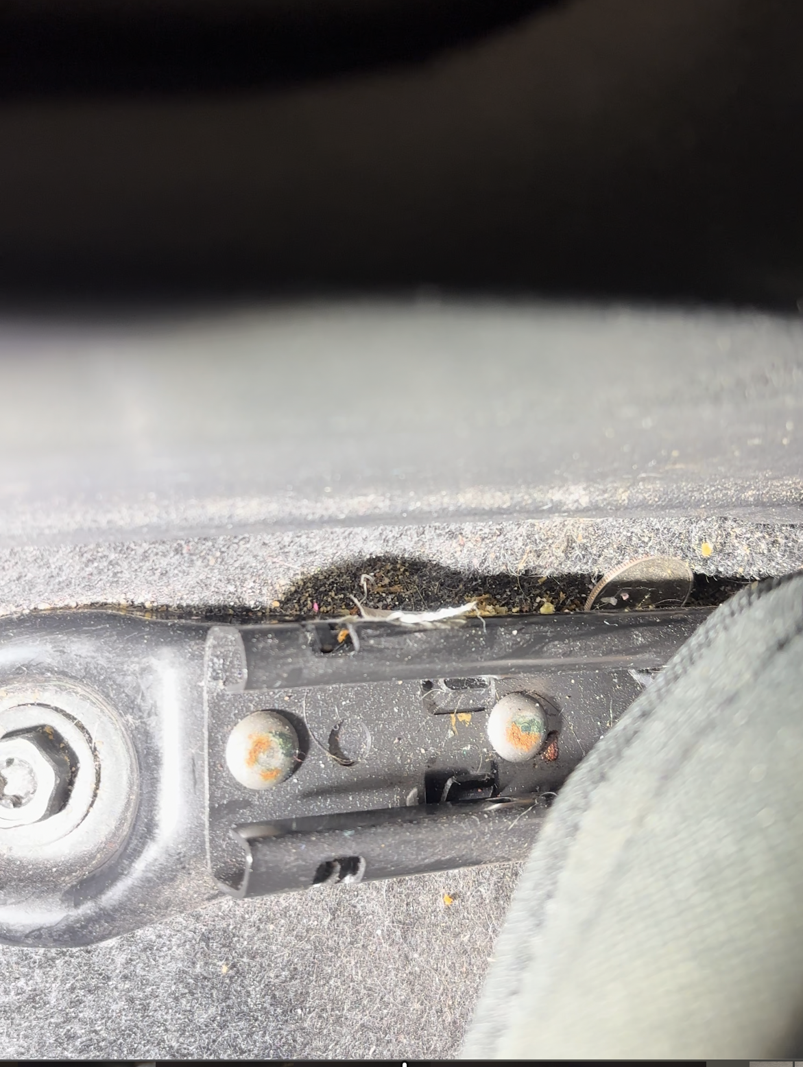 A dirty seat rail where odor causing bacteria and debris is commonly left behind by detailing shops that aren't properly trained in odor removal.