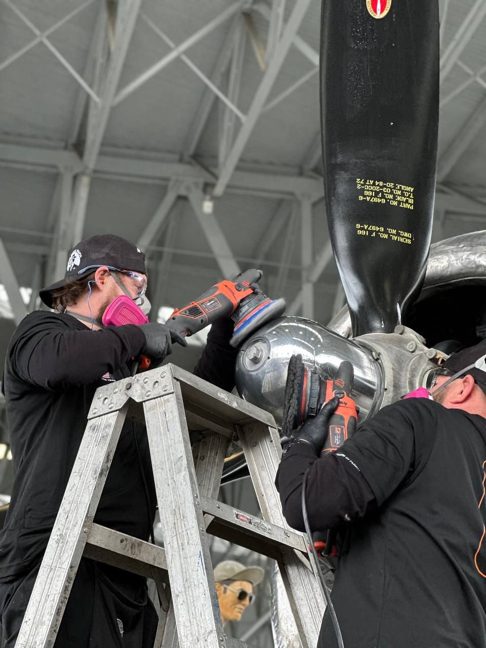 Britt Stokes polishing the tip of the engine turbine on the B-29 bomber name T-Square 54.