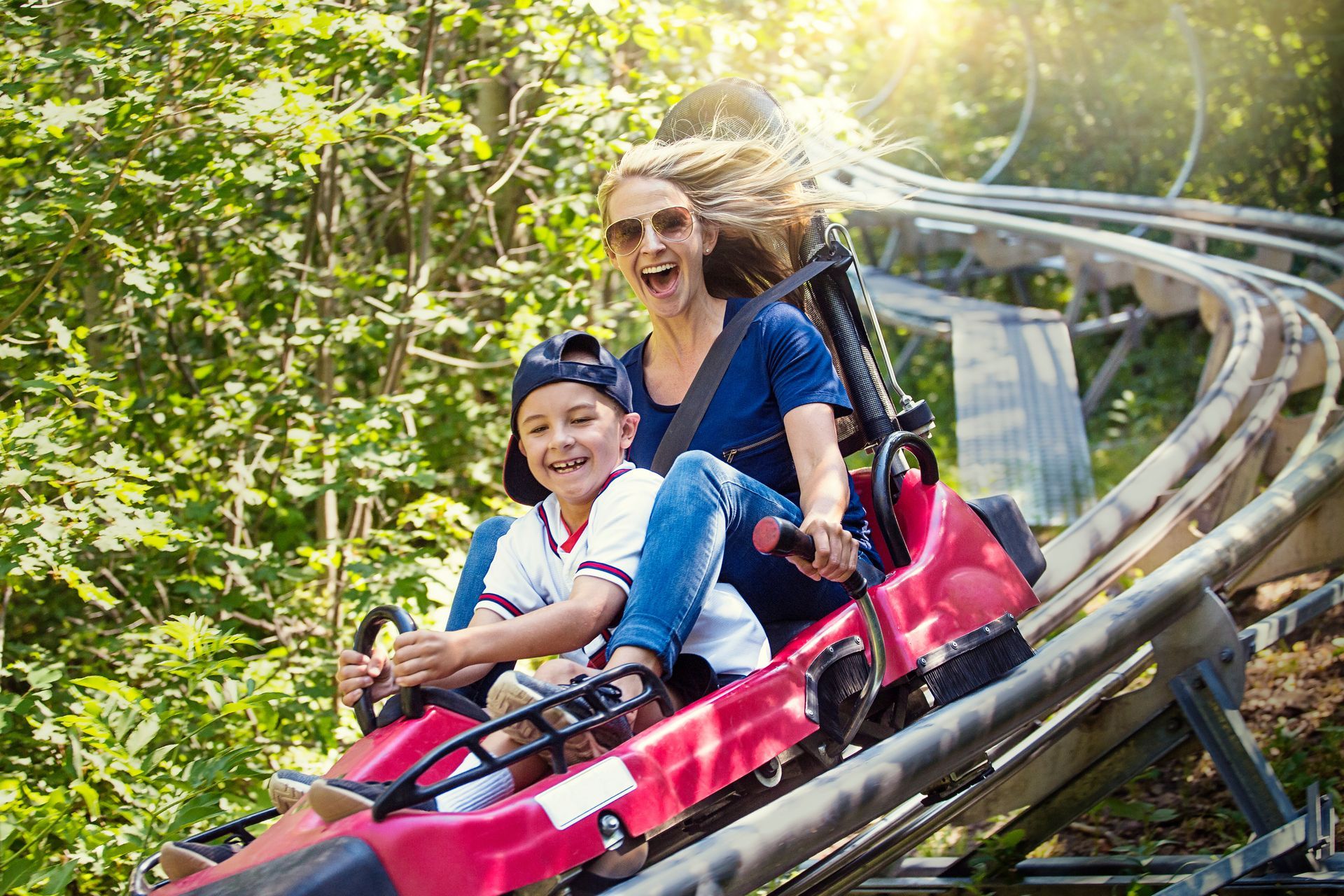 A woman and a boy are riding a roller coaster.