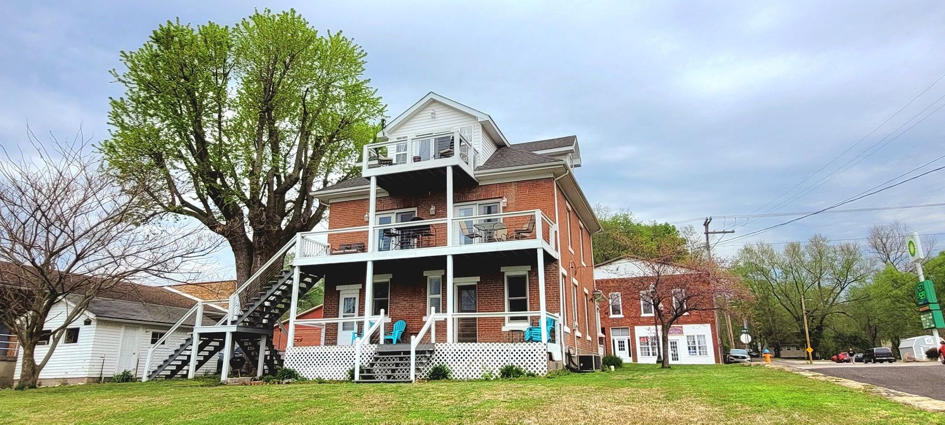 A large brick house with a tree in front of it