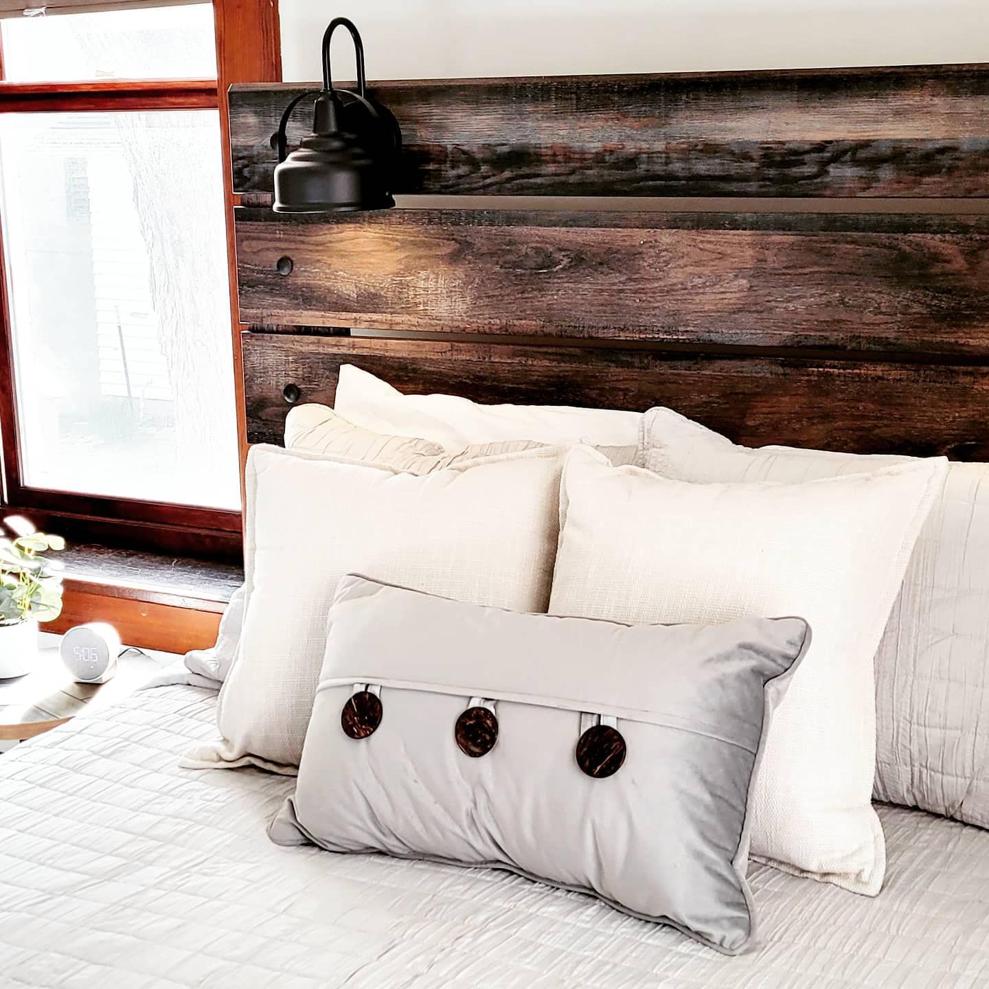 A bed with white pillows and a wooden headboard