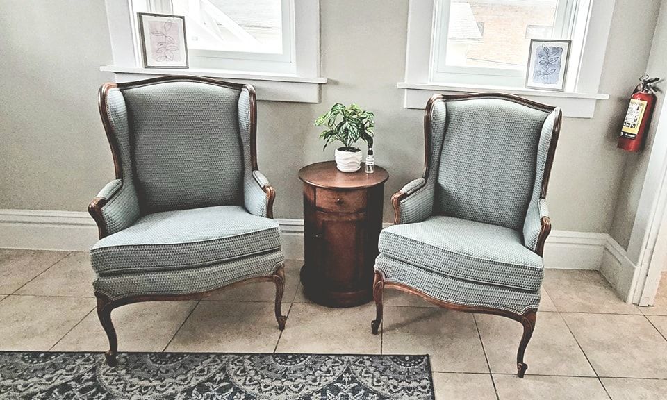 Two chairs and a table in a room with a fire extinguisher