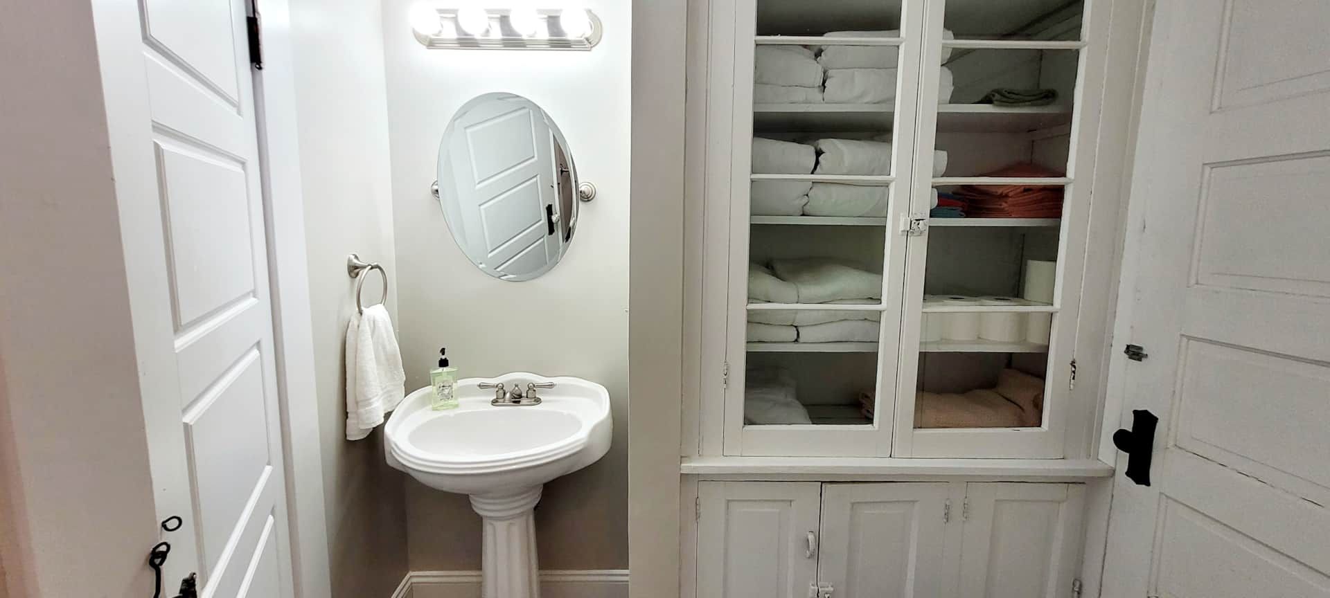 A bathroom with a sink , mirror and cabinets.