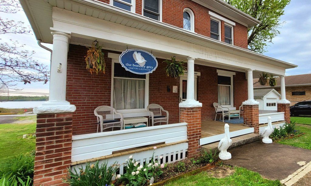 A brick house with a porch and chairs on it