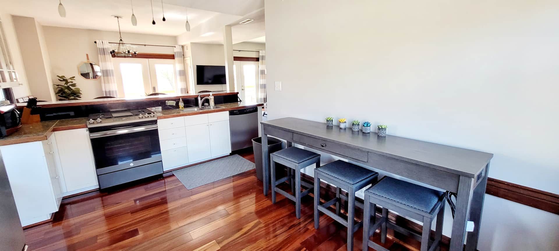 A kitchen with a table and stools in it.