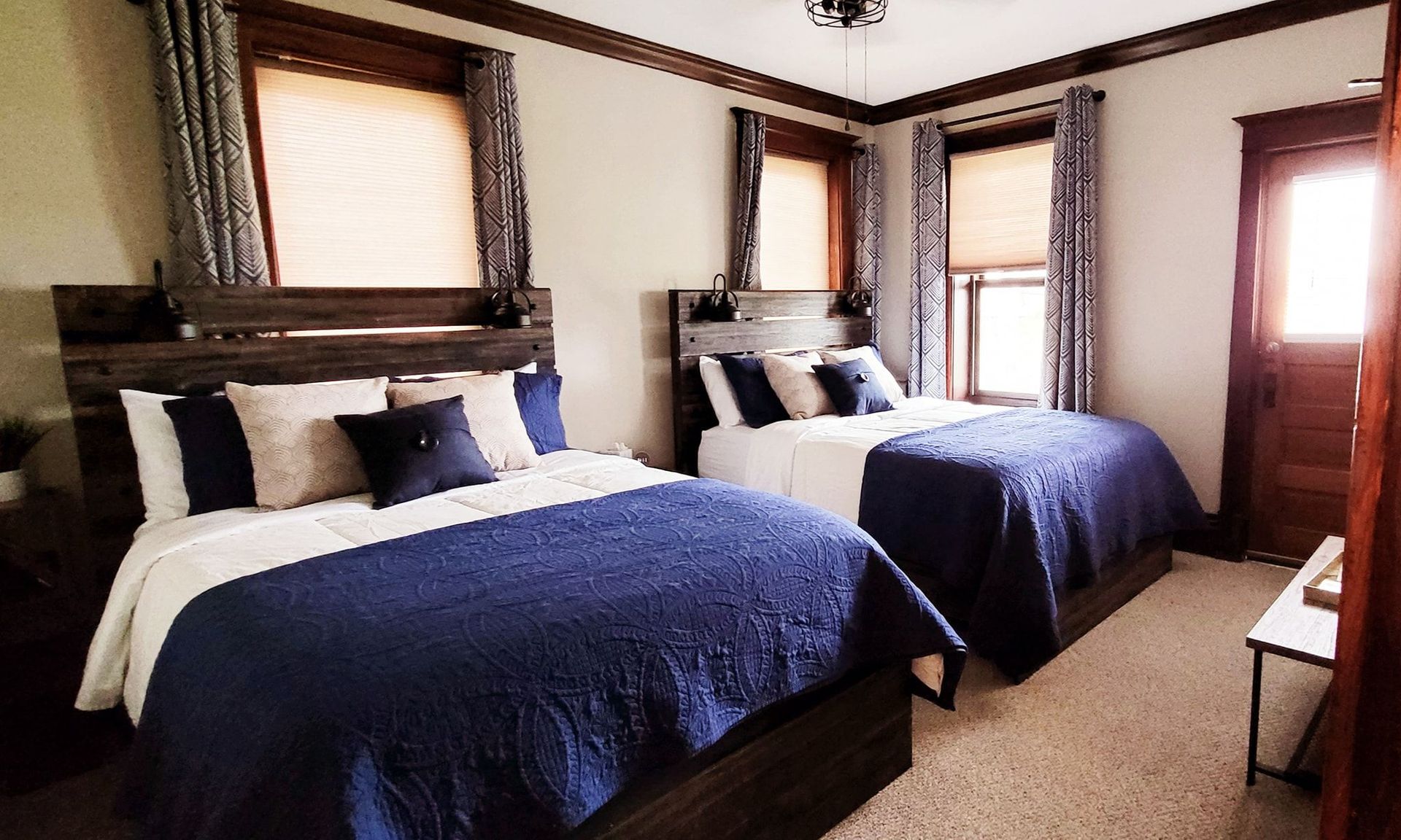 A bedroom with two beds and two windows