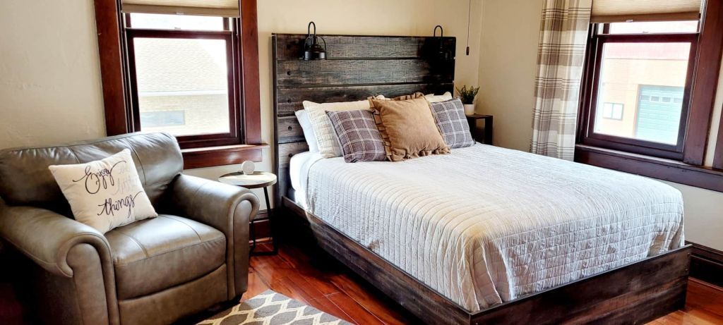 A bedroom with a bed , chair , and window.