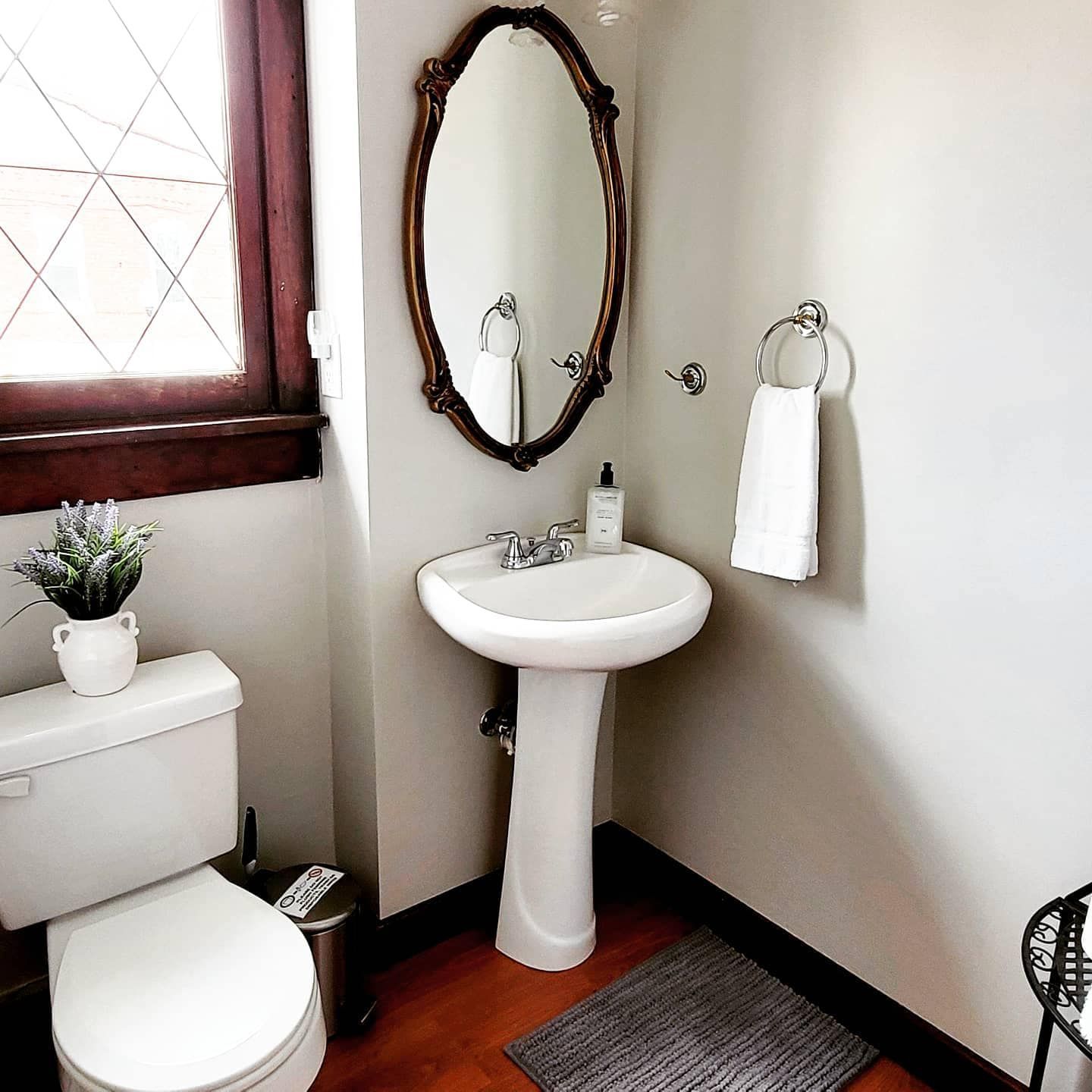 A bathroom with a toilet a sink and a mirror
