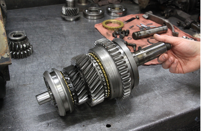 A person is working on a gear on a table.