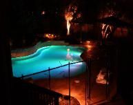 A large swimming pool is lit up at night.