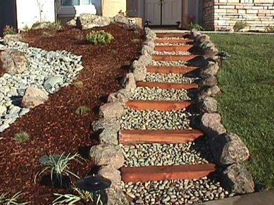 A stone walkway with wooden steps leading up to a house.