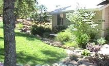 A house with a lush green lawn and trees in front of it.