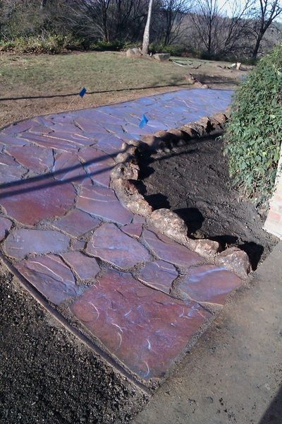 A stone walkway is being built in a yard.