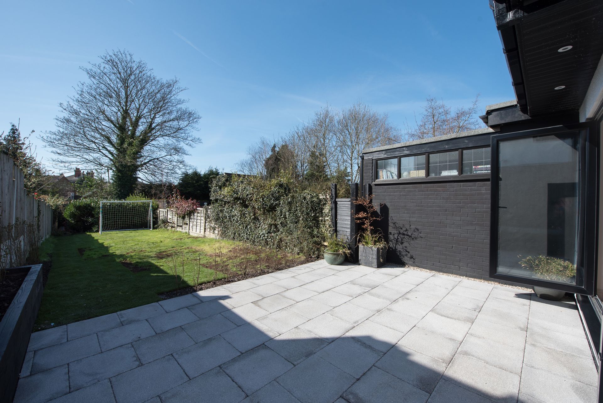 There is a patio in the backyard of a house.
